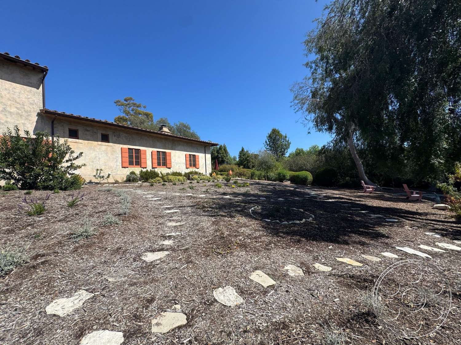 Farmstead Garden - low-maintenance garden, terracotta roof tiles, stepping stone pathway, sunny exterior, stucco exterior walls, rural farmhouse setting, decorative garden stones, orange window shutters, xeriscape landscaping, wood mulch ground cover