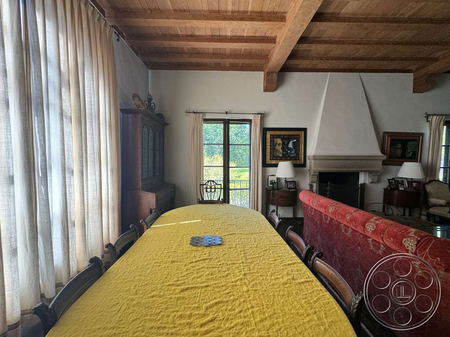 Farmstead Garden - abstract wall art, wood dining table, floor-to-ceiling windows, textured plaster walls, wooden dining chairs, traditional armchair, exposed wood ceiling beams, stone fireplace surround, linen tablecloth, light sheer curtains