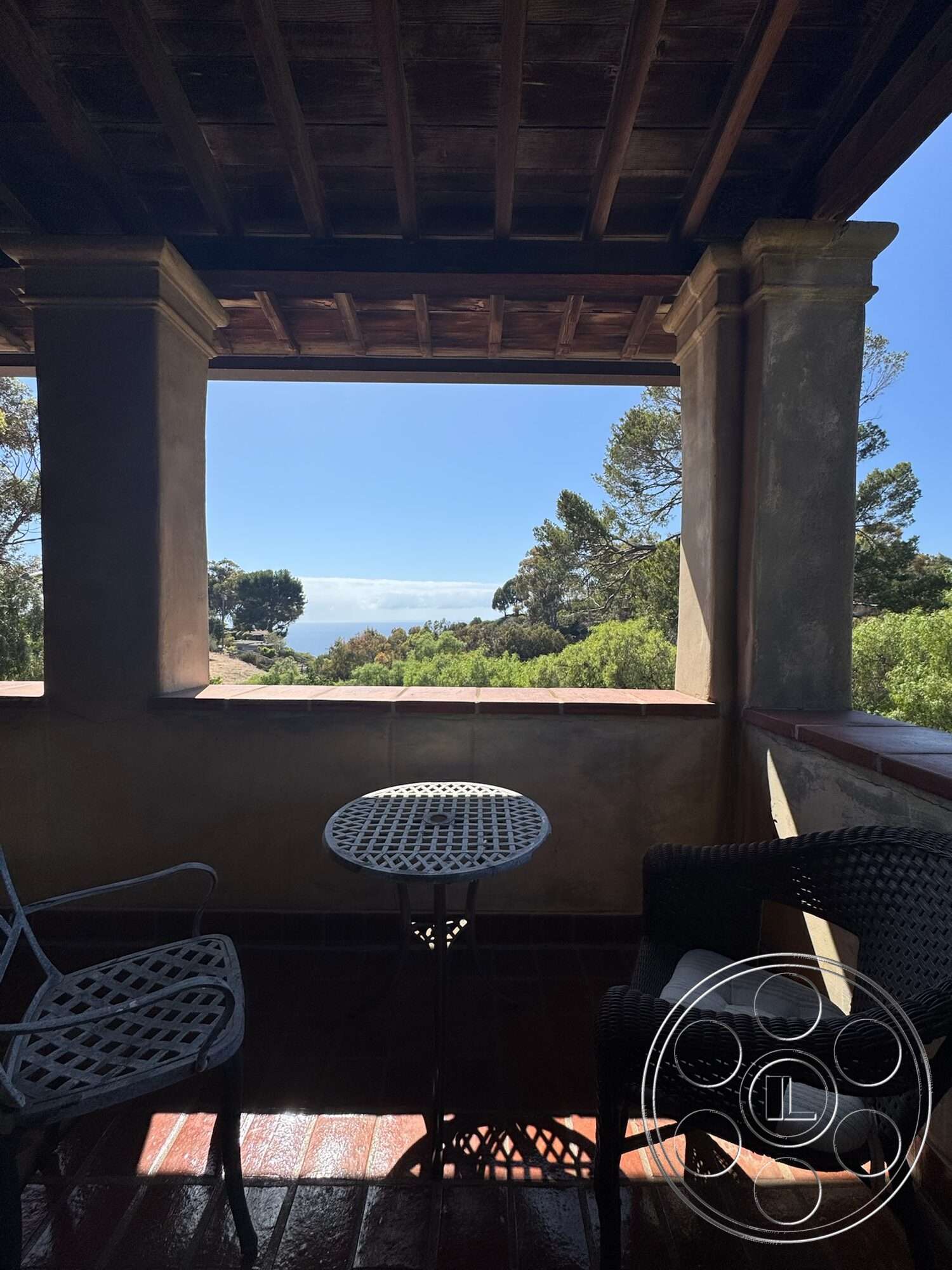 Farmstead Garden - exterior, terracotta tile flooring, wrought iron chairs, mountain view setting, wood beam ceiling, stucco wall treatment, open balcony space, metal bistro table