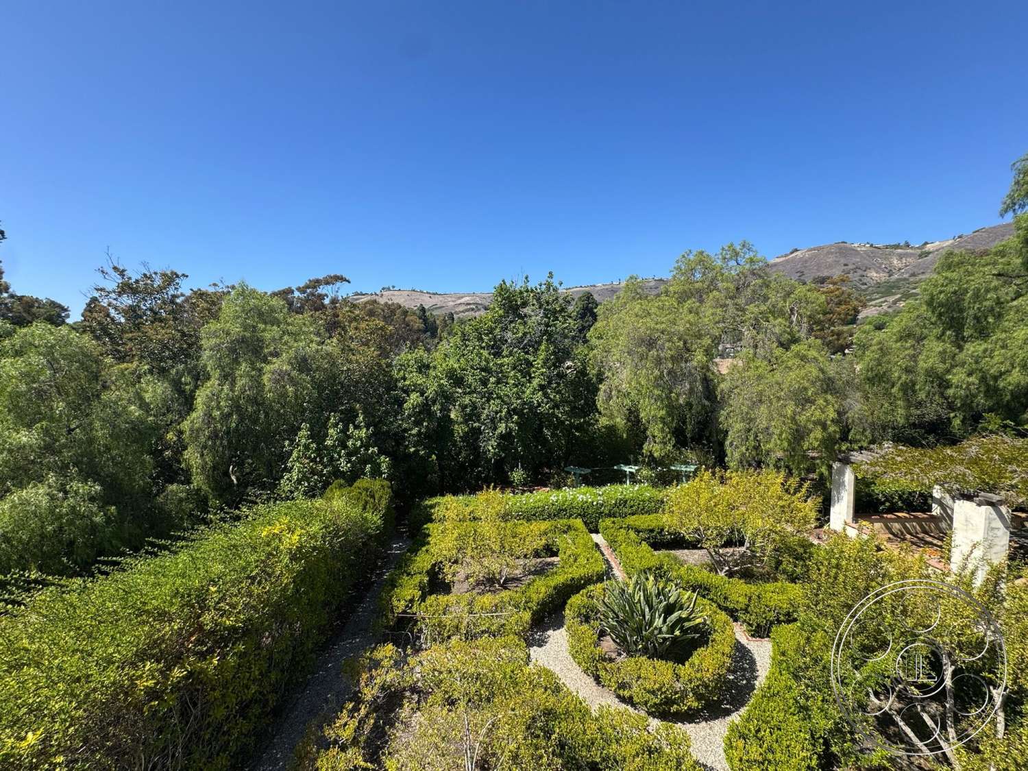 Farmstead Garden - exterior, landscaped garden, gravel pathways, mountain view, clear blue sky, flower beds, agave plants, ornamental trees, hedge borders, lush green foliage