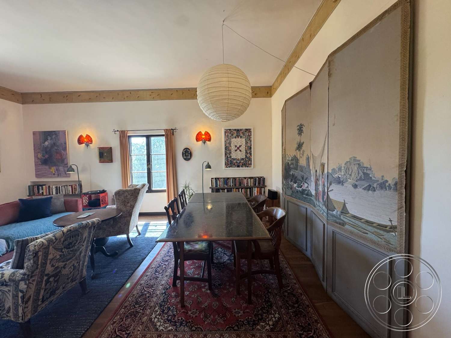 Farmstead Garden - hardwood flooring, open layout, dining area, floor-to-ceiling windows, textured plaster walls, rectangular dining table, upholstered armchair, wall-mounted sconces, wood beam ceiling, artwork wall decor, curtains with tiebacks, vintage patterned rug, bookshelf with closed storage, Asian-inspired wall tapestry