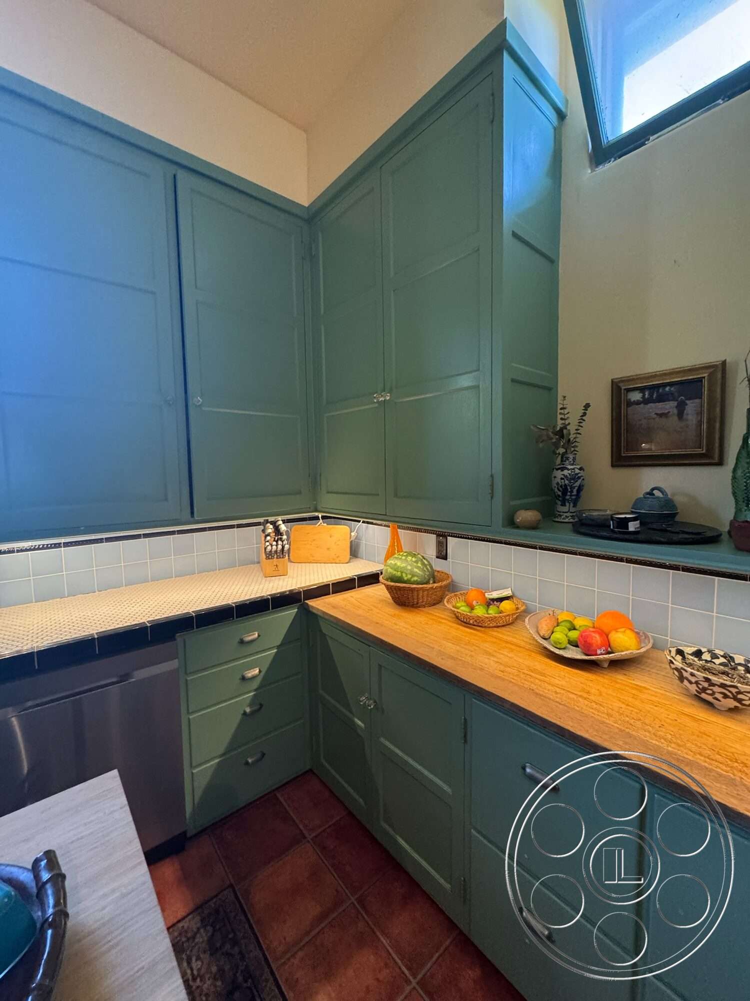 Farmstead Garden - stainless steel appliances, ceramic tile flooring, wood countertop, textured wall treatment, natural light from window, interior kitchen, tile kitchen backsplash, green painted cabinetry, corner kitchen layout, decorative fruit bowls