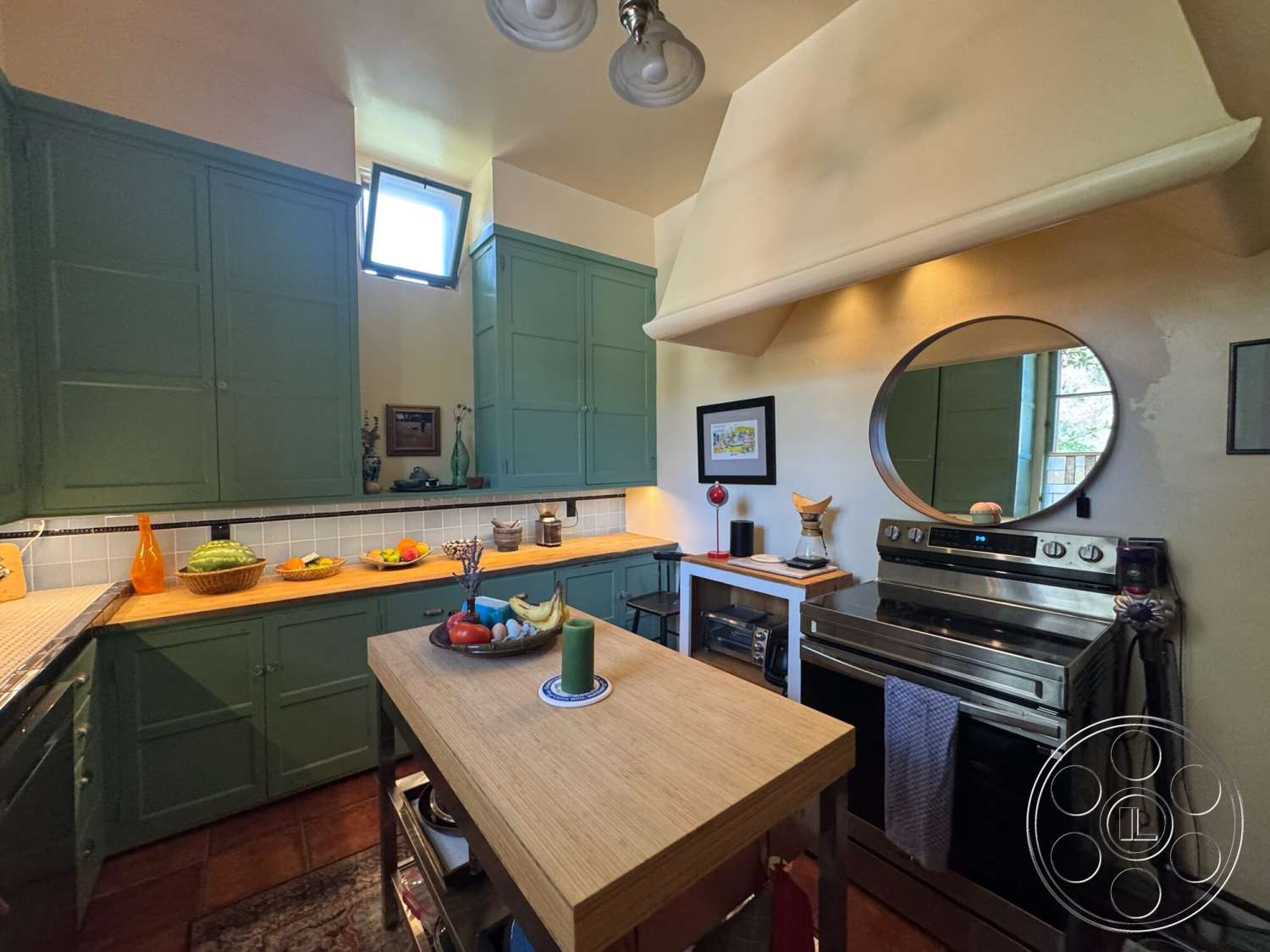 Farmstead Garden - stainless steel appliances, open shelving, decorative wall art, wood countertop, window with natural light, kitchen accessories, terra cotta floor tiles, circle mirror, green cabinetry, interior kitchen, tile kitchen backsplash, square dining table, copper range hood, pendent lighting