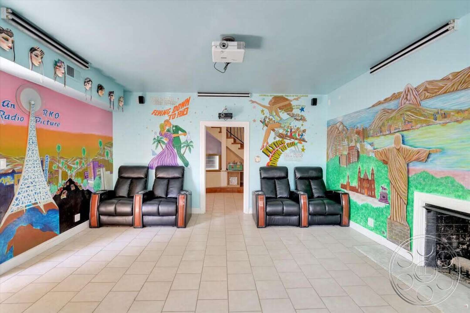 Spanish 170 - ceramic tile flooring, decorative wall art, textured plaster ceiling, ambient ceiling lighting, fireplace with stone surround, open doorway design, projector screen area, multicolored mural walls, black leather reclining chairs