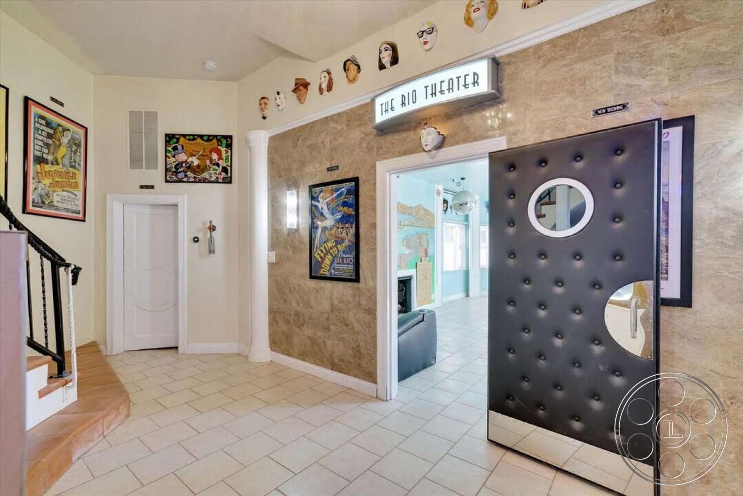 Spanish 170 - exterior, lighting fixtures, decorative wall art, textured plaster walls, polished tile flooring, white painted walls, wood staircase with curved steps, black tufted door, round window detail, film-themed decor