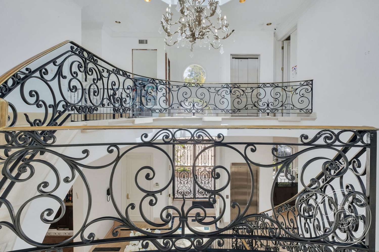 French 29 - high ceilings, floor-to-ceiling windows, spiral staircase, chandelier lighting, arched doorway, elevator access, black wrought iron railing, white painted walls, wood handrail