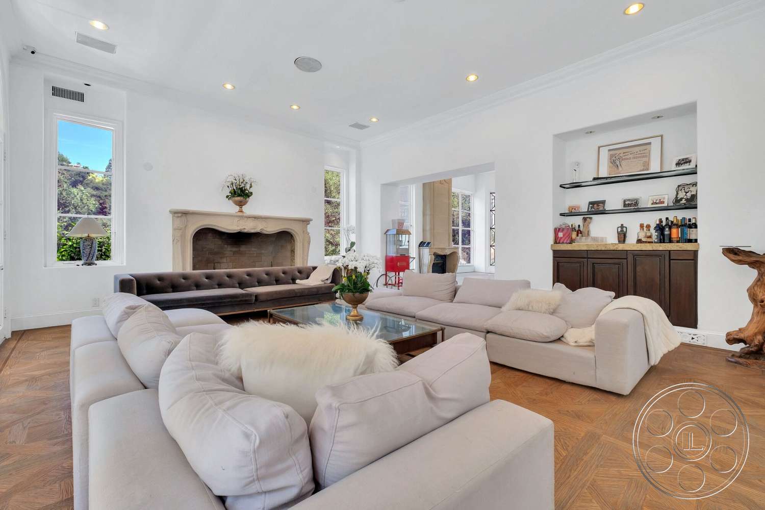 French 29 - neutral color palette, glass coffee table, minimalist design elements, modern decor accents, recessed ceiling lighting, white painted walls, decorative indoor plants, upholstered sectional sofa, built-in wooden shelving, hardwood herringbone flooring, large windows with views, exposed stone fireplace, tufted leather sofa