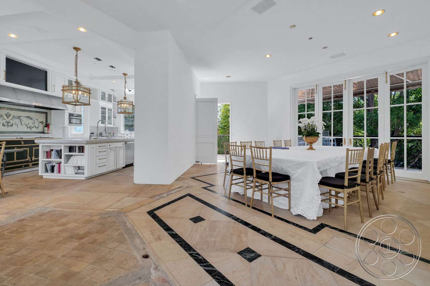 French 29 - floor-to-ceiling windows, arched doorways, textured plaster walls, contemporary dining area, glass pendant lighting, chef's kitchen, open floor plan layout, white painted walls, outdoor patio access, tile kitchen floors, exposed brick kitchen accent, dark stone inlay flooring, linear kitchen island, gold finish dining chairs, decorative backsplash tile