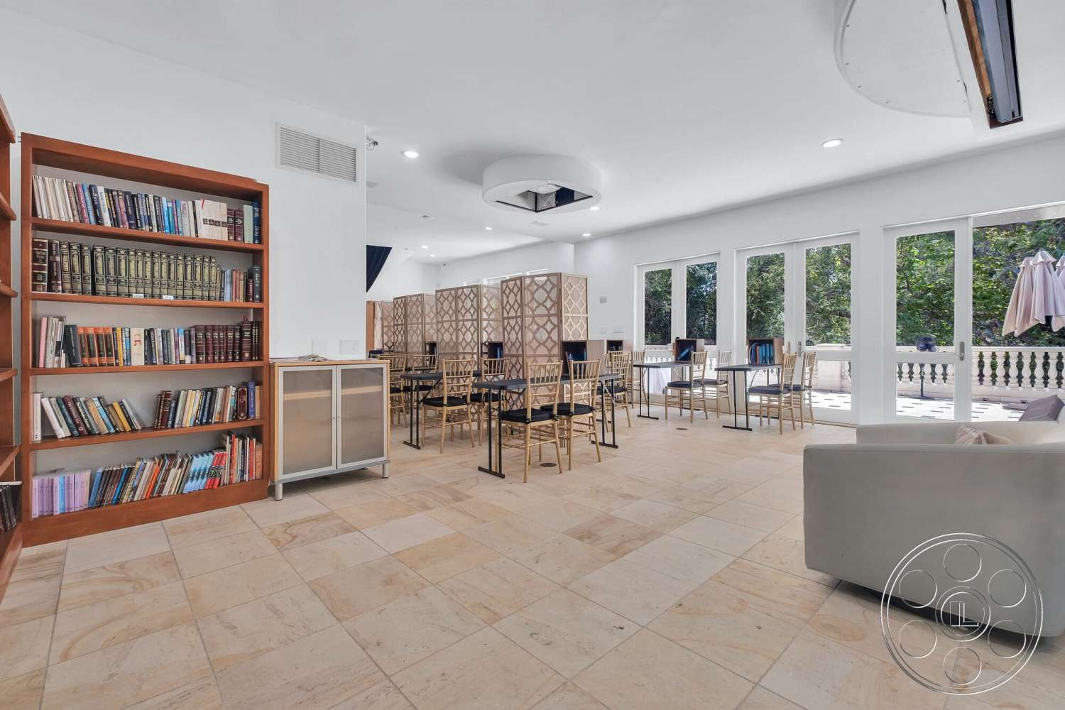French 29 - neutral color palette, modern decor, minimalist design, open floor plan, glass sliding doors, natural stone flooring, geometric pendant lighting, metal dining chairs, wooden bookshelf with books, large windows with garden view, soft seating area, textured wall dividers