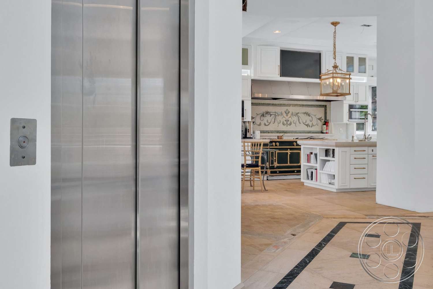 French 29 - floor-to-ceiling windows, white cabinetry, gold hardware, large kitchen island, contemporary kitchen design, open concept kitchen, pendant lighting fixture, marble kitchen backsplash, stainless steel elevator doors, natural stone floor tiles, wooden kitchen chair, decorative kitchen details