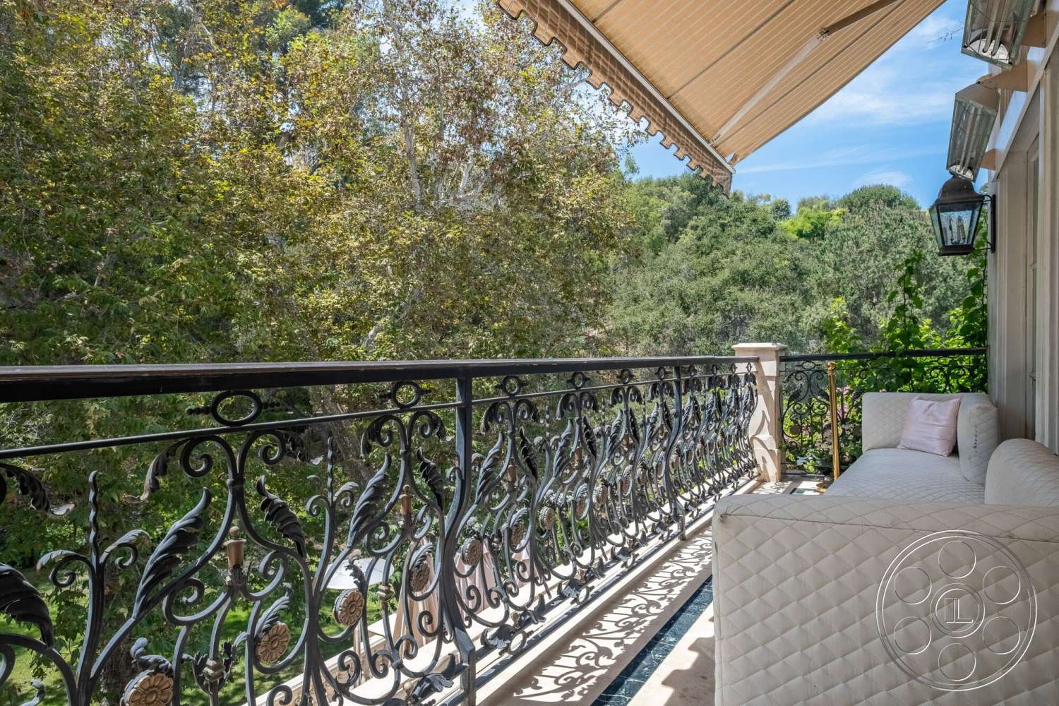 French 29 - natural setting, ornate wrought iron railing, exterior balcony, comfortable outdoor seating, sunny patio area, wooden ceiling overhang, diverse tree foliage view