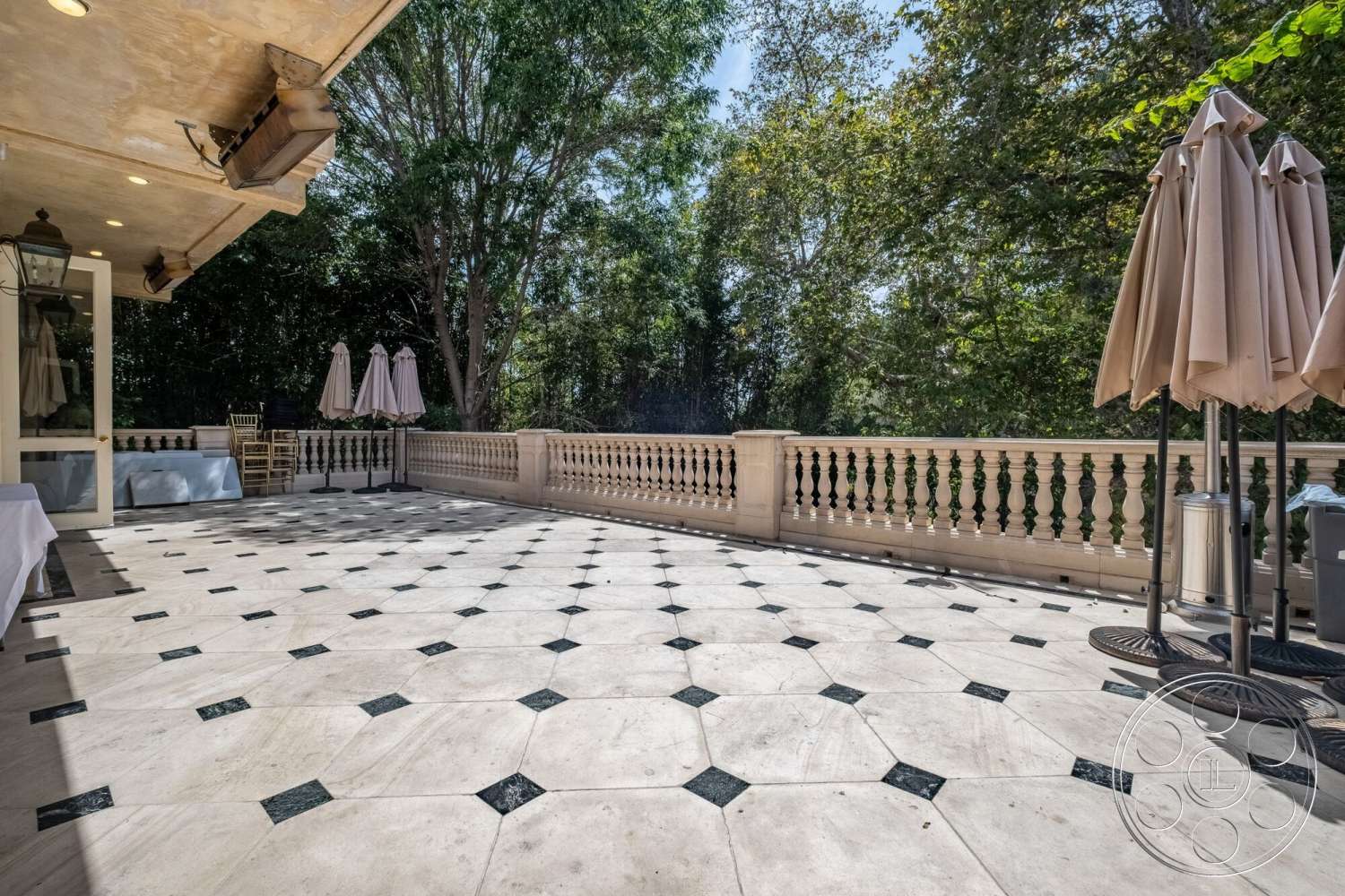 French 29 - exterior, surrounding trees, outdoor dining area, sunshade umbrellas, lush garden view, wood beam ceiling, decorative stone balustrade, marble patio flooring, octagonal patterned tile, black granite inlays