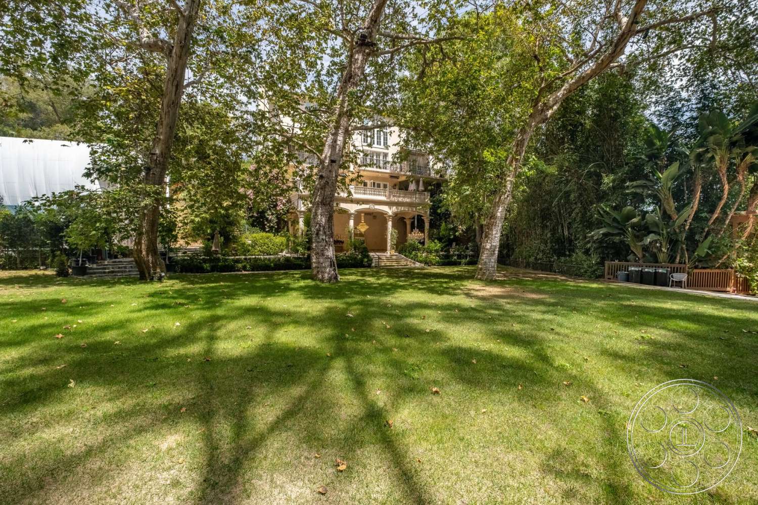 French 29 - exterior, outdoor seating area, mature trees, stone pathway, traditional architectural style, two-story home, wooden porch steps, green lawn area, landscape garden beds, surrounding shrubbery, natural light from surrounding foliage