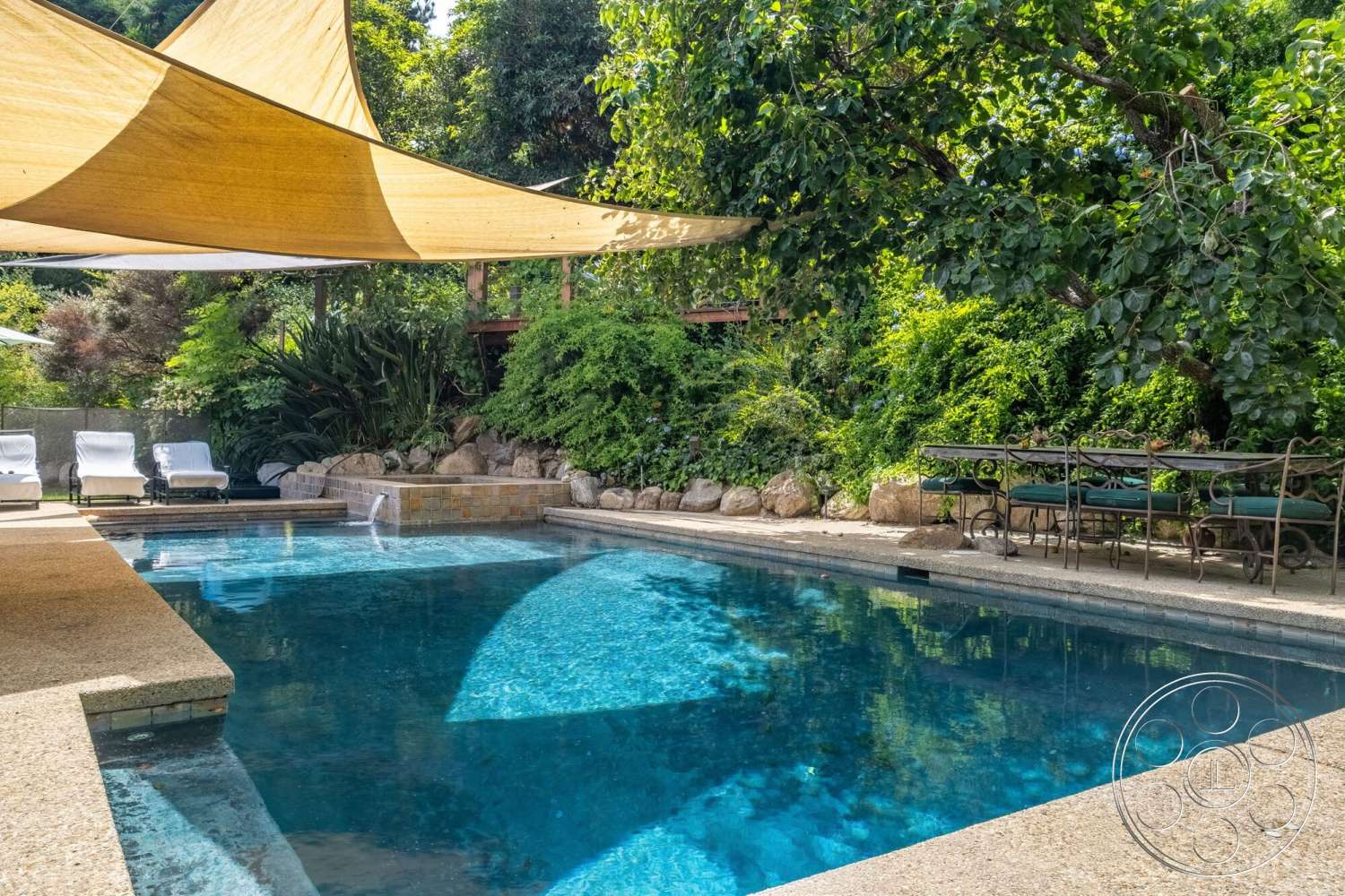French 29 - exterior, outdoor dining area, tropical greenery, rectangular pool, concrete pool border, concrete patio floor, stone garden accents, deck with lounge chairs, texture rock landscaping, shade sail awning