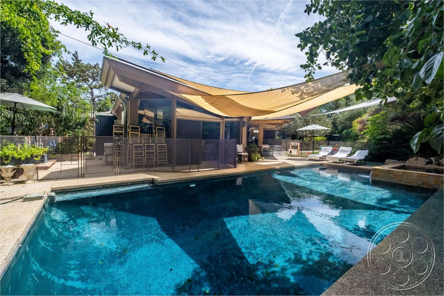 French 29 - exterior, outdoor dining area, textured concrete flooring, modern architectural style, sun loungers, concrete pool deck, stone feature wall, rectangle swimming pool, landscaped garden area, glass window wall, wooden patio chairs, fabric shade structure, oversized umbrellas