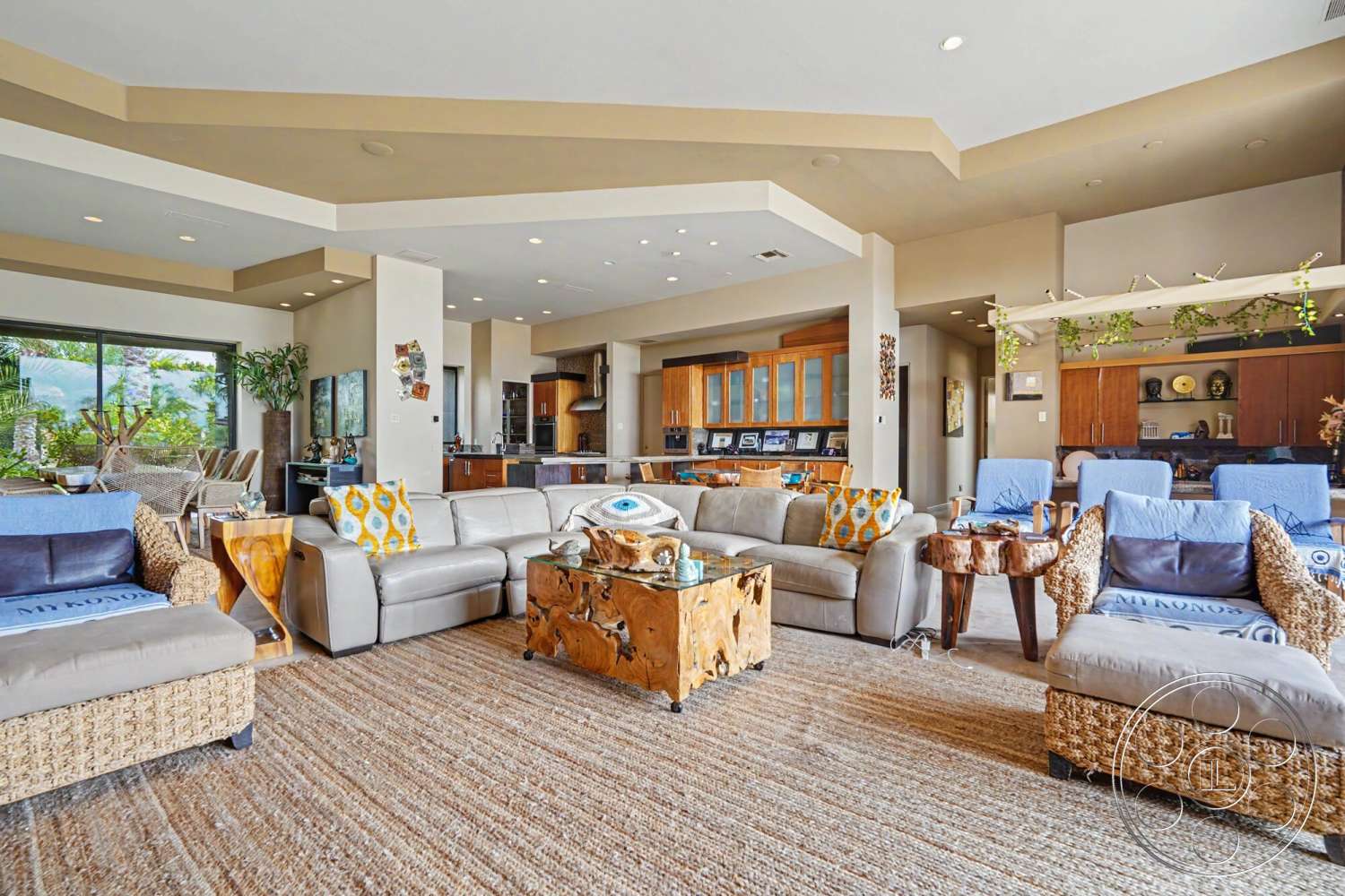 Rancho Mirage 4 - neutral color palette, bar seating area, modern decor elements, floor-to-ceiling windows, lush indoor plants, leather sectional sofa, textured carpet flooring, exposed ceiling with recessed lighting, open plan living space, decorative throw pillows with geometric patterns, woven armchairs, dark wood cabinetry in kitchen, coffee table made from natural wood