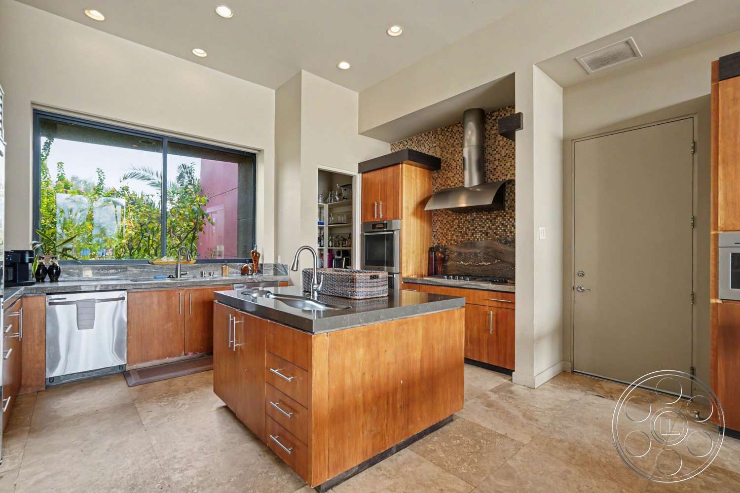 Rancho Mirage 4 - natural light, open floor plan, stainless steel appliances, floor-to-ceiling windows, contemporary design elements, textured stone backsplash, modern kitchen design, interior kitchen, travertine tile flooring, granite countertop island, walnut kitchen cabinets, built-in pantry storage