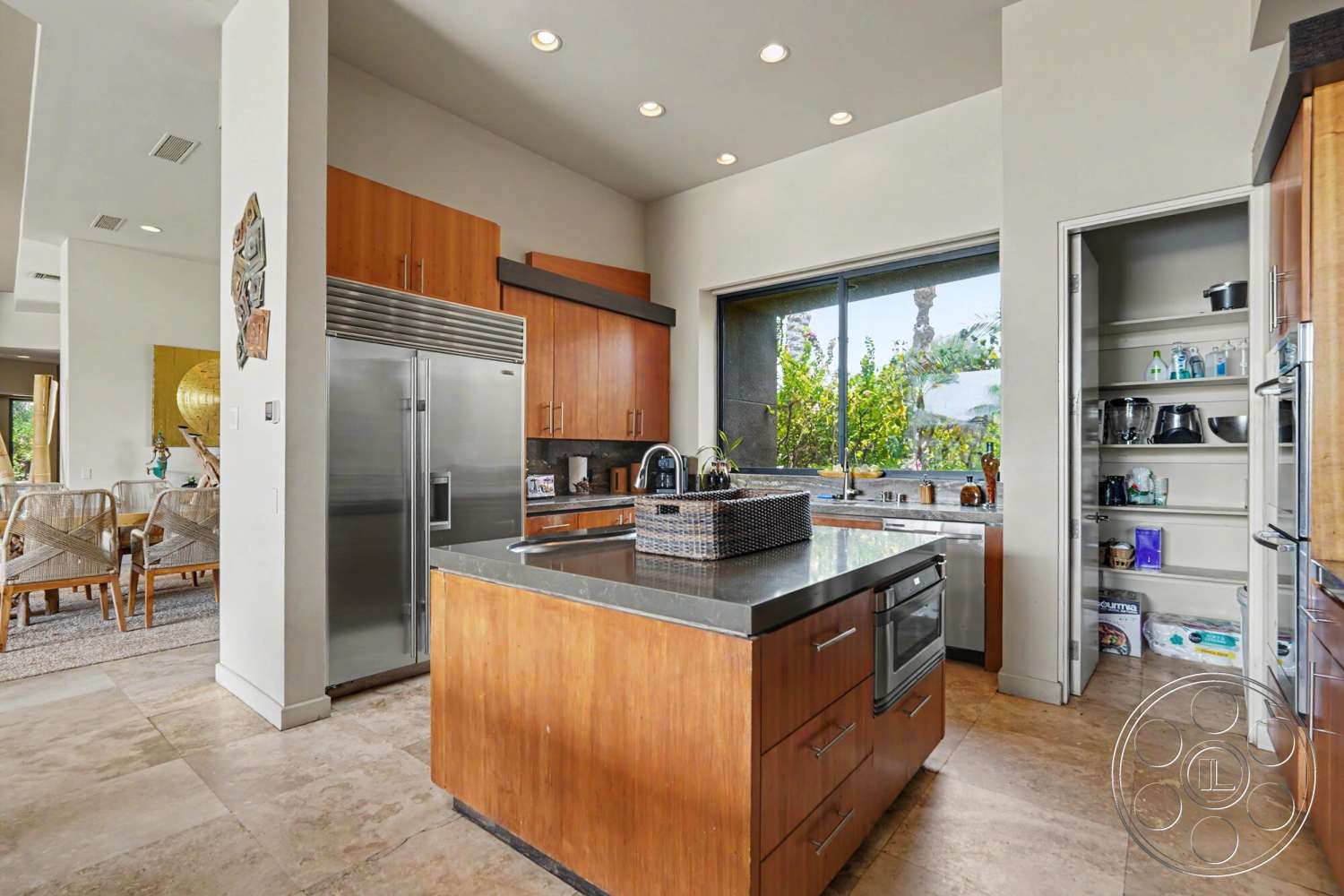 Rancho Mirage 4 - natural light, wood cabinetry, floor-to-ceiling windows, stainless steel refrigerator, neutral color scheme, pantry door, modern kitchen design, open concept kitchen, kitchen island with seating, tile kitchen flooring, concrete countertop island