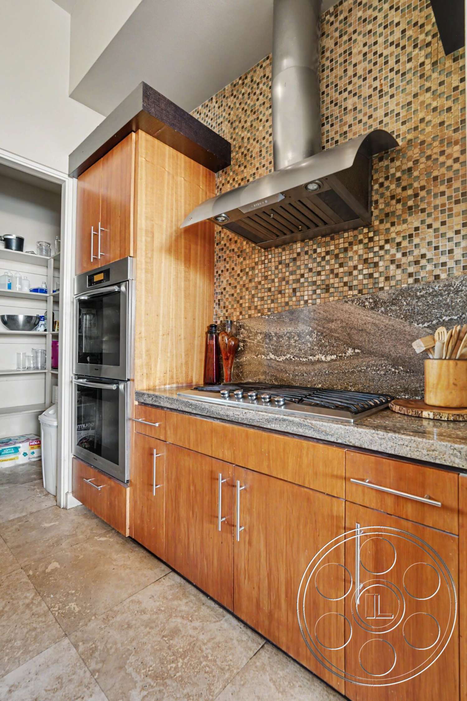 Rancho Mirage 4 - wood cabinetry, granite countertop, built-in oven, silver hardware, modern kitchen design, stainless steel range hood, marble floor tiles, mosaic tile backsplash