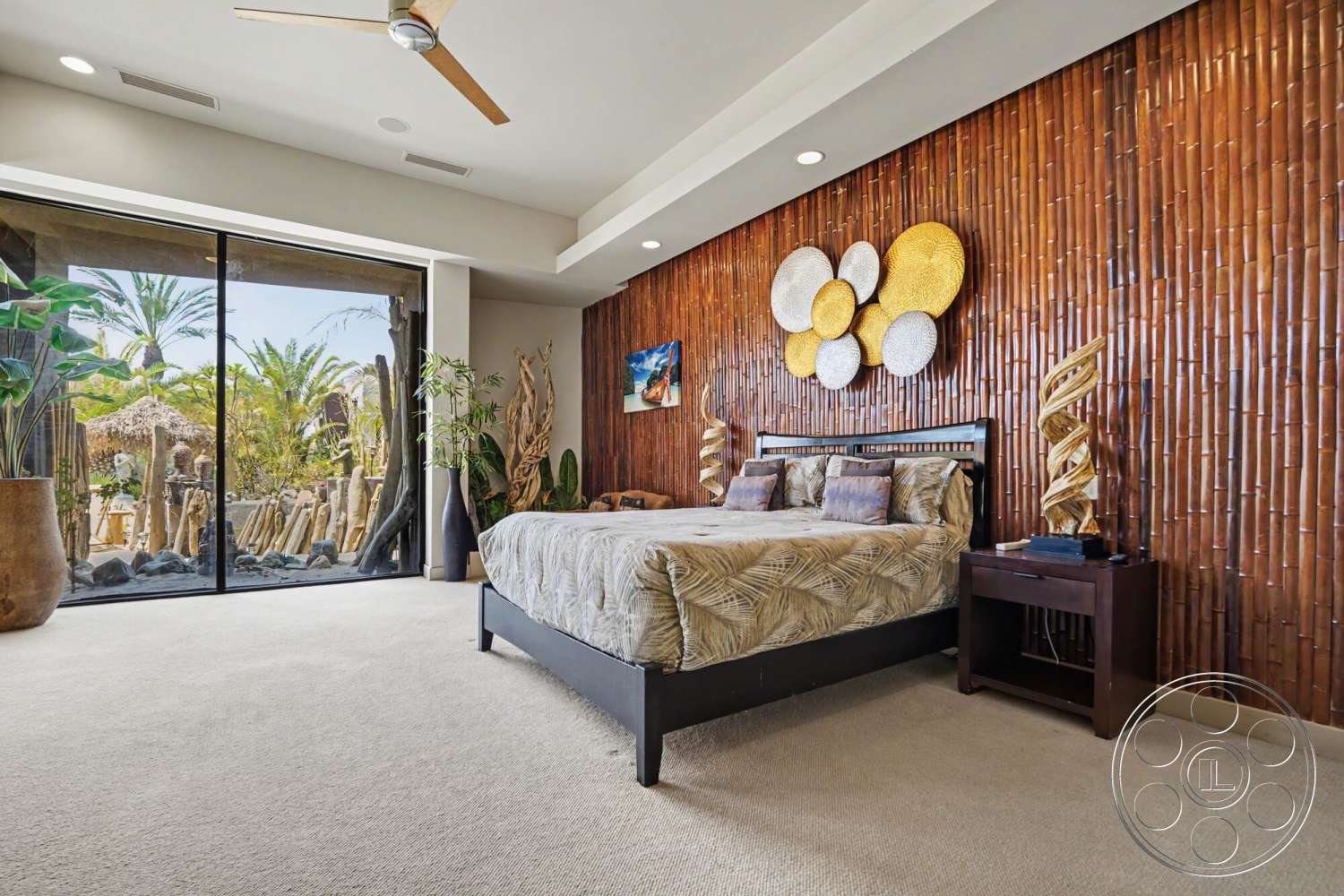 Rancho Mirage 4 - neutral color palette, glass sliding doors, decorative wall art, modern ceiling fan, light-colored bedding, textured wall details, bamboo accent wall, tropical plant decor, carpet bedroom flooring, contemporary bedside table, stylish bedroom furniture