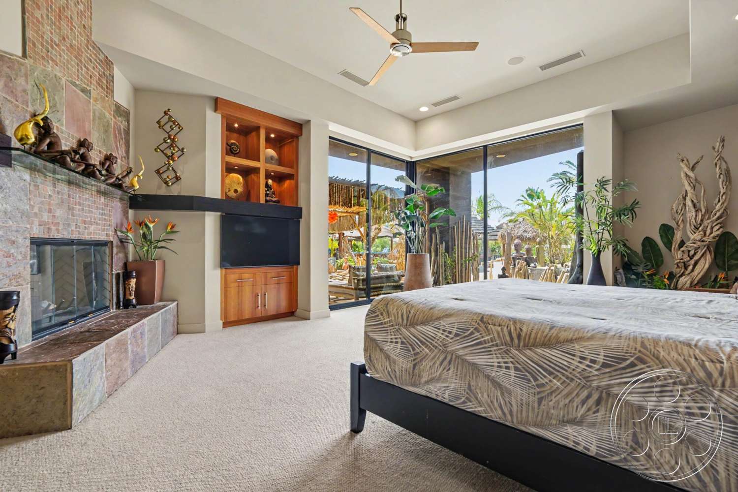 Rancho Mirage 4 - indoor plants, ceiling fan, floor-to-ceiling windows, brick fireplace surround, open-concept space, exposed brick accent wall, carpet bedroom flooring, wood built-in cabinets
