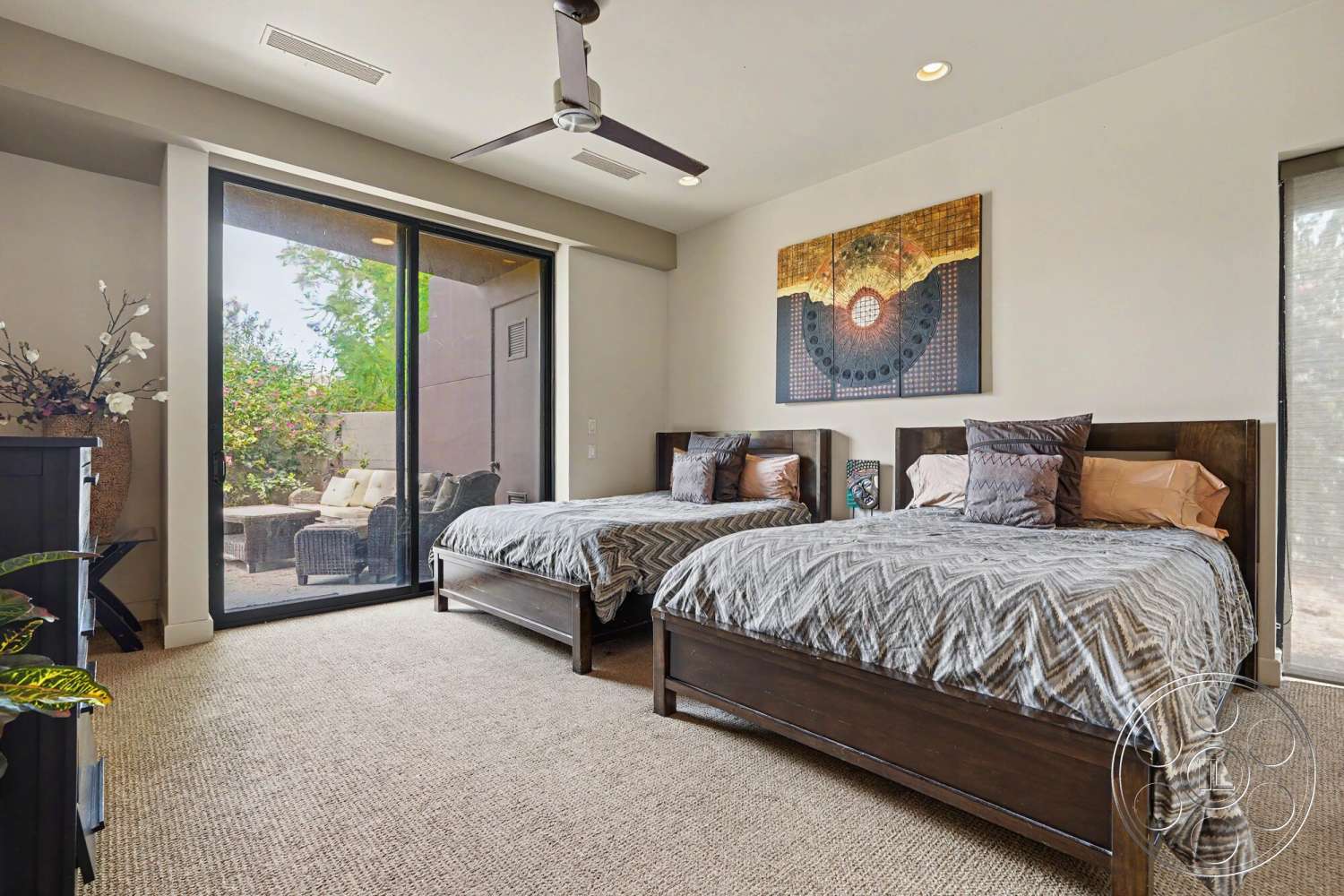 Rancho Mirage 4 - natural light, textured wall art, floor-to-ceiling windows, sliding glass door, modern ceiling fan, neutral painted walls, carpet bedroom flooring, guest bedroom, wood bed frames, plant decor elements, bedside pillows