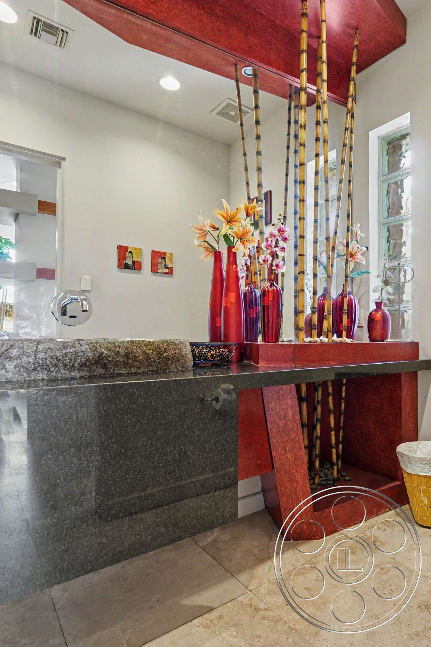 Rancho Mirage 4 - ceramic tile flooring, under-mounted sink, contemporary lighting fixtures, natural stone accent, granite bathroom countertop, red acrylic wall panel, slender bamboo decor, vase filled with flowers, modern straightforward cabinetry