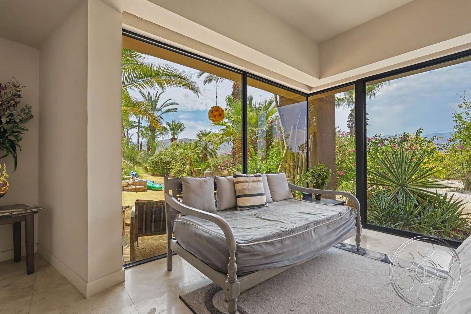 Rancho Mirage 4 - marble flooring, textured wall treatment, palm trees outside, contemporary architectural style, decorative indoor plants, minimalist furniture design, floor-to-ceiling glass windows, framed view of garden