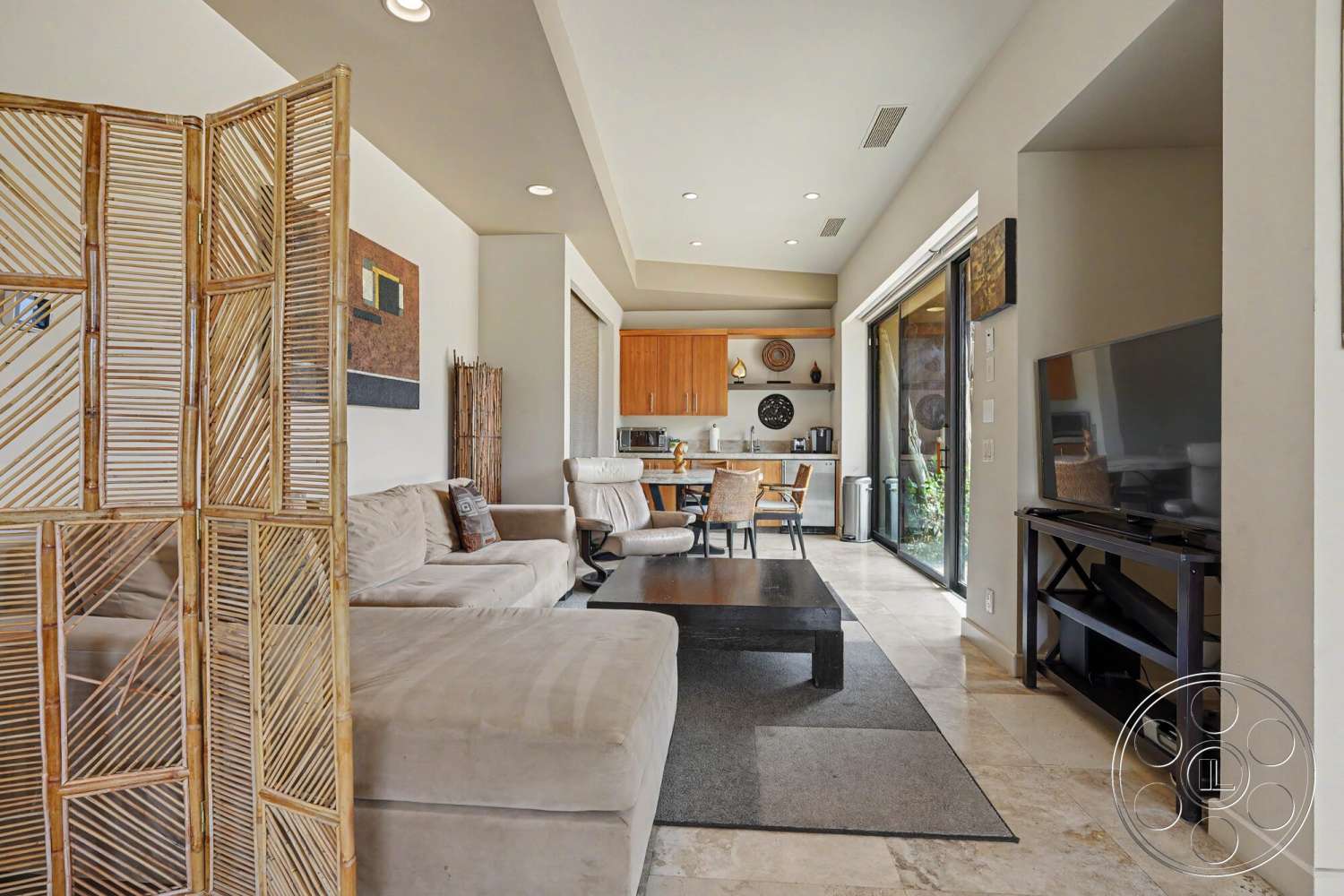 Rancho Mirage 4 - neutral color palette, tile flooring, recessed lighting, large glass sliding doors, open concept layout, decorative wall art, textured wall treatment, contemporary dining area, dark wood coffee table, modern minimalist design, light wood kitchen cabinetry, bamboo room divider, soft fabric sectional sofa, natural stone tile