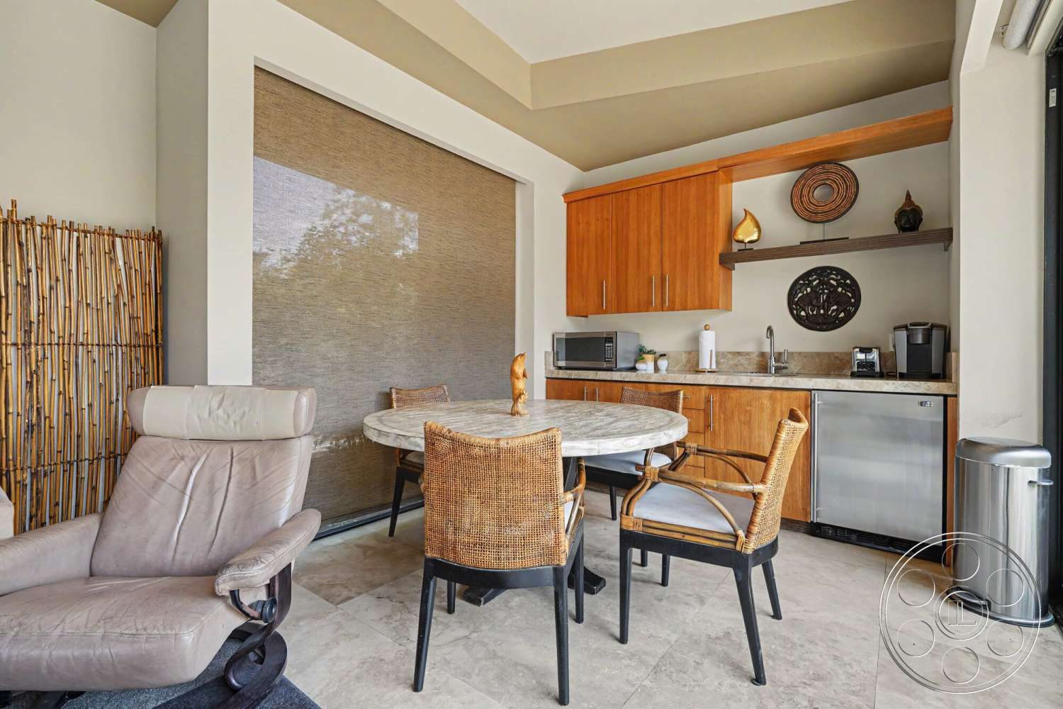 Rancho Mirage 4 - open shelving, ceramic tile flooring, light wood cabinetry, decorative wall art, textured plaster walls, modern kitchen appliances, marble dining table, granite kitchen countertop, bamboo accent wall, woven rattan dining chairs, leather lounge chair