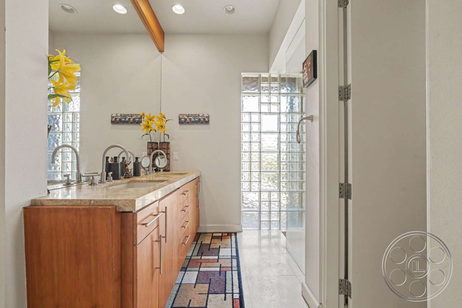 Rancho Mirage 4 - textured area rug, recessed ceiling lights, contemporary bathroom design, white painted walls, single-story layout, floating bathroom sink, dark wood vanities, granite bathroom countertops, glass block shower walls, open space bathroom