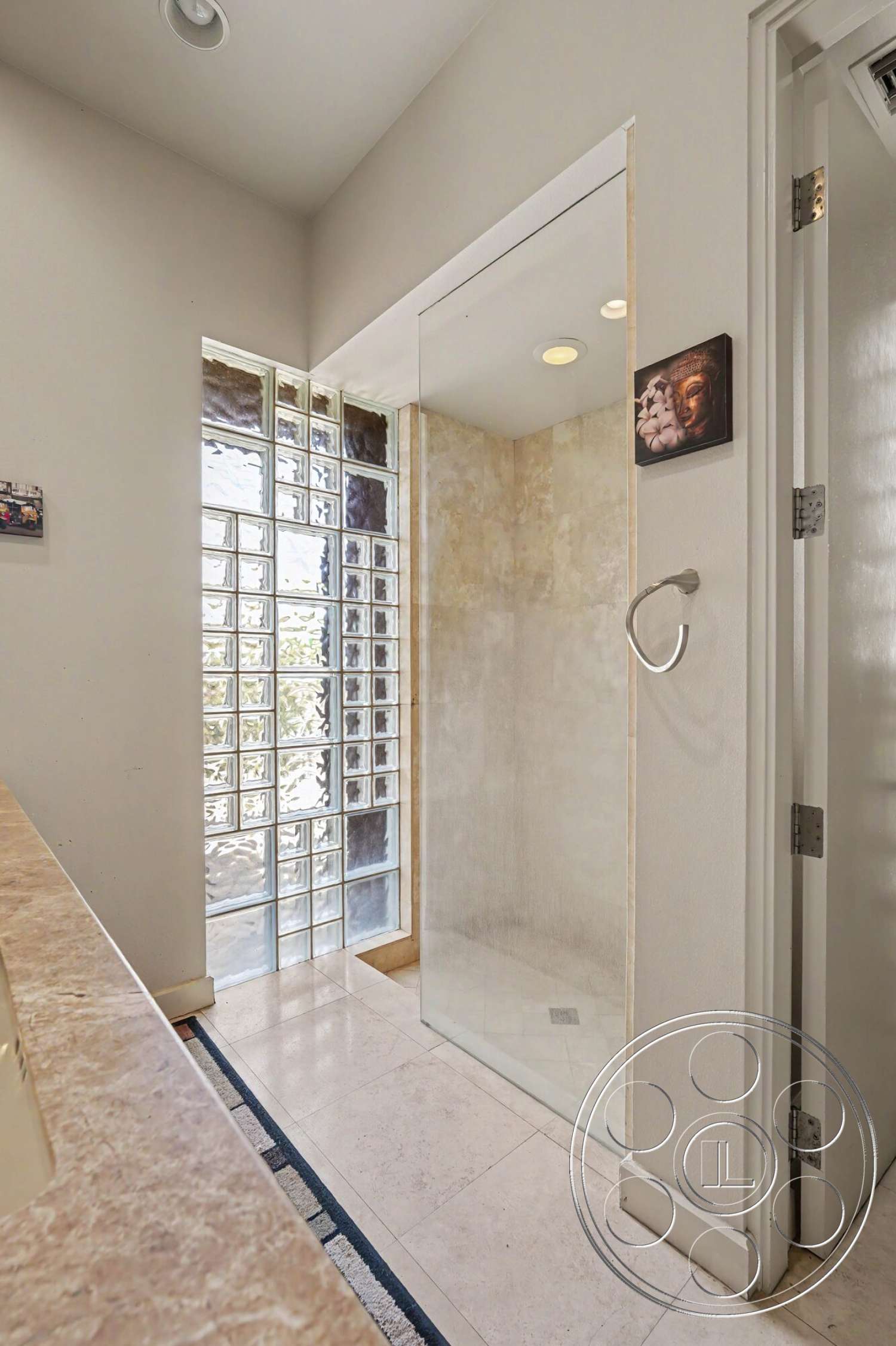 Rancho Mirage 4 - recessed ceiling lighting, modern bathroom design, white painted walls, marble bathroom flooring, glass block shower wall, framed glass shower doors, brushed nickel towel ring