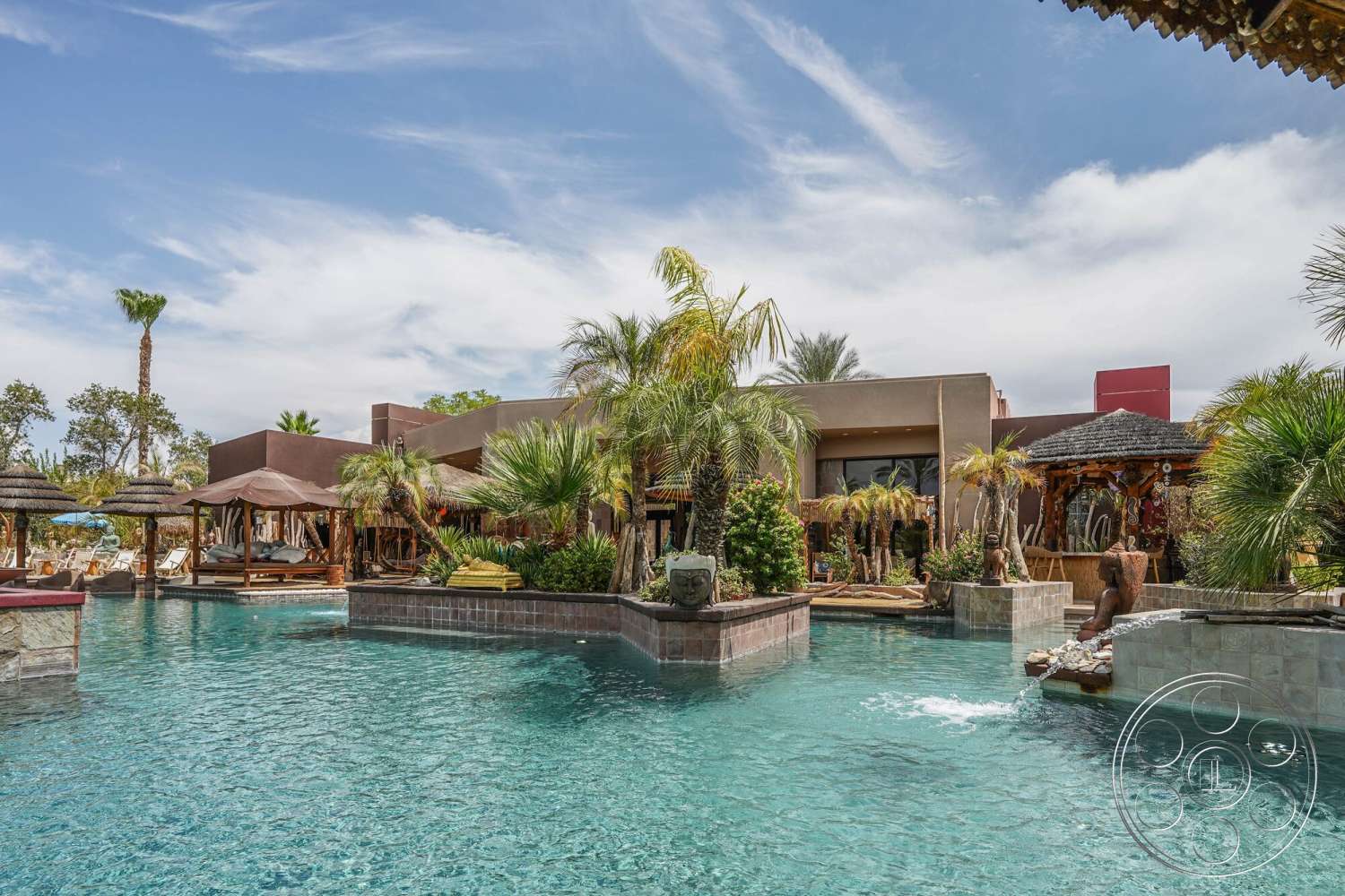 Rancho Mirage 4 - exterior, palm trees, floor-to-ceiling windows, wooden pergola, thatched roof cabana, outdoor lounging area, garden landscaping, rectangular pool, stone pool deck, modern home design, concrete patio area, tile water feature