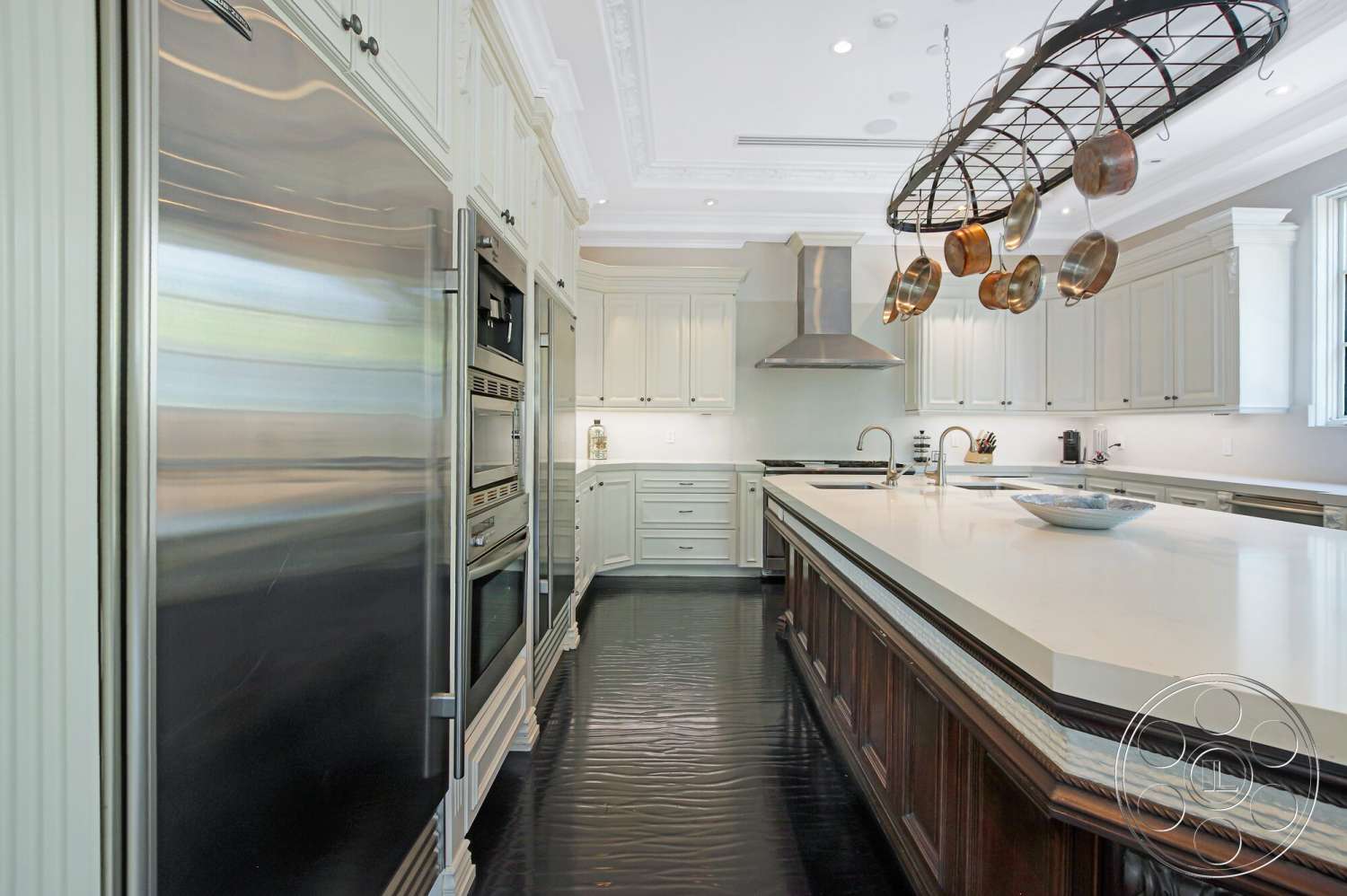 Medit 170 - dark wood cabinetry, recessed lighting, marble countertops, stainless steel refrigerator, island with seating, black tile flooring, modern faucet, interior kitchen, stainless steel range hood, large windows with natural light, classic crown molding, hanging pot rack, stainless steel built-in ovens, white painted shaker style cabinets