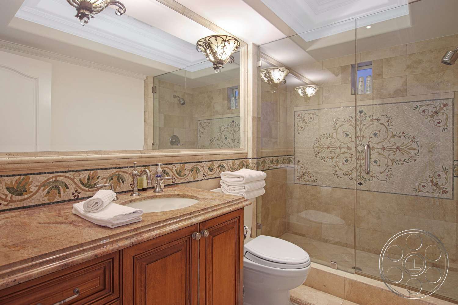 Medit 170 - wood cabinetry, glass shower enclosure, neutral wall color, elegant light fixtures, framed mirror, undermount sink, recessed ceiling lighting, interior bathroom, granite bathroom countertop, dual vanity sinks, textured stone wall tiles, decorative mosaic tile backsplash, classic toilet