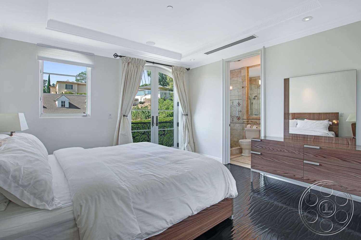 Medit 170 - light-colored walls, curtains, floor-to-ceiling windows, white bedding, balcony with wrought iron railing, hardwood bedroom floors, glass door opening to balcony, framed mirror on dresser, modern dresser design, simple light fixtures, en-suite bathroom access