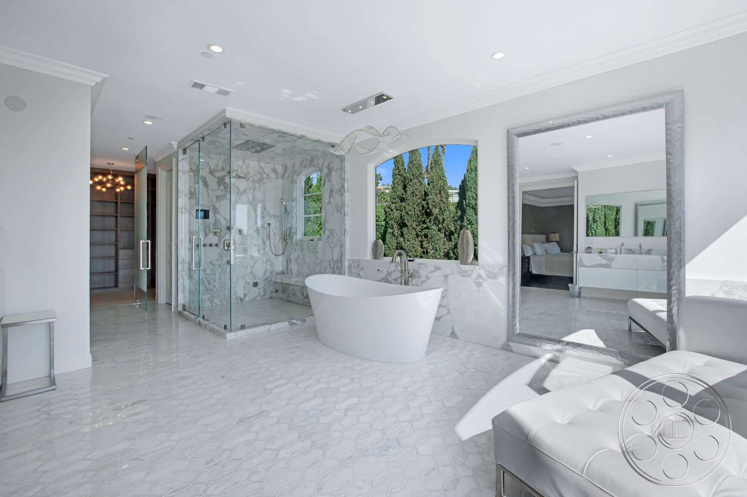 Medit 170 - freestanding bathtub, glass shower enclosure, stone feature wall, textured mirror frame, large picture window, modern bathroom design, white painted walls, exposed ceiling lights, marble bathroom flooring, white upholstered chaise lounge