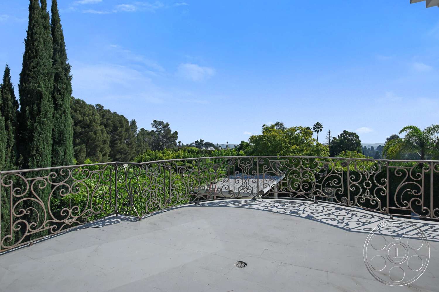 Medit 170 - exterior, cypress trees, sloped landscape, lush greenery view, wrought iron balcony railing, concrete balcony floor, curved balcony shape, sunny sky, leaded glass details