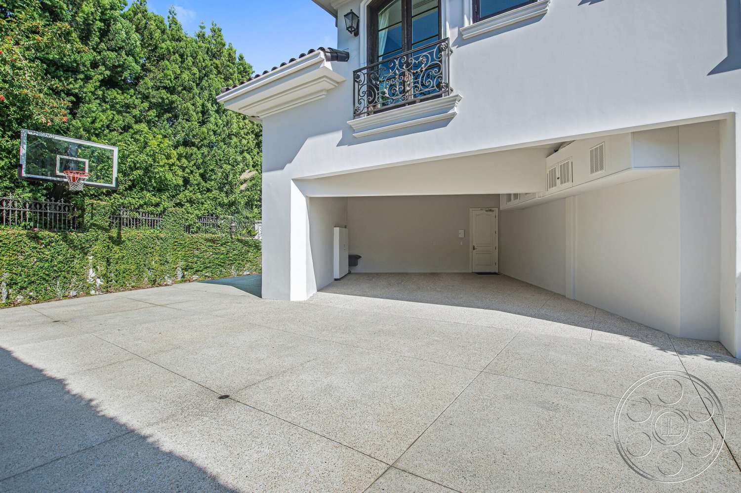 Medit 170 - exterior, white stucco walls, flat roof, basketball hoop, balcony with wrought iron railing, exposed aggregate concrete driveway, landscaped garden with hedges, double garage door opening