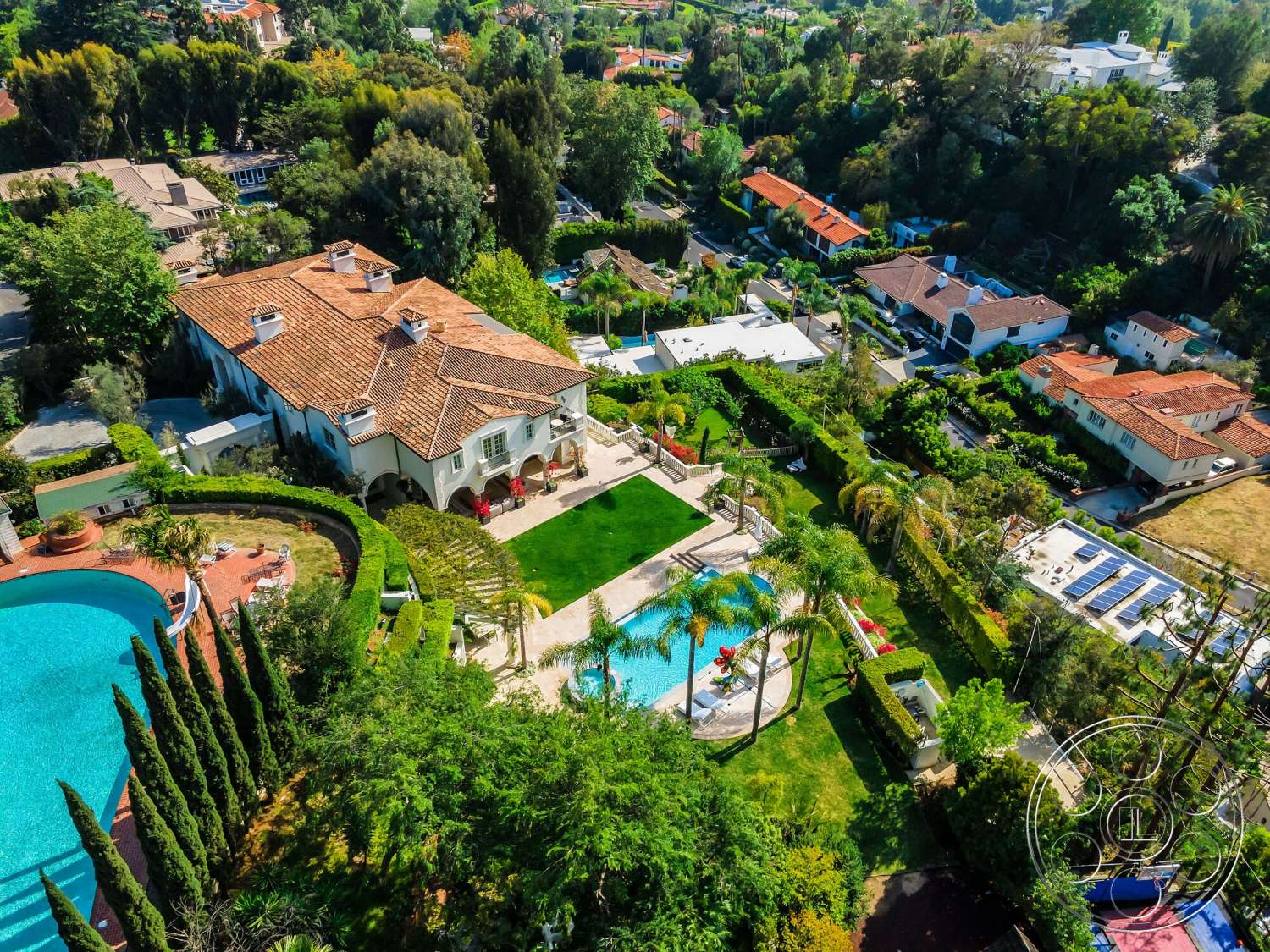 Medit 171 - exterior, palm trees, outdoor seating area, surrounding residential neighborhood, tall cypress trees, stucco walls, arched doorways, terracotta tile roof, landscaped garden area, brick patio flooring, sunny hillside location, Mediterranean style house, circular swimming pool, green manicured lawns