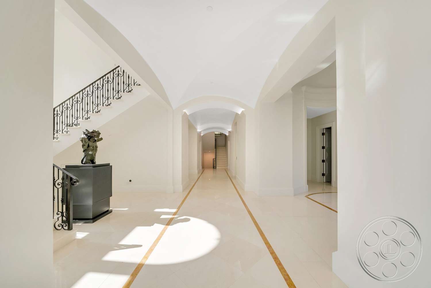 Medit 171 - minimalist decor, open floor plan, double doors, marble flooring, elegant foyer, white painted walls, curved ceiling design, archway ceilings, wrought iron stair railing, sculptural accent piece, gold inlay floor design
