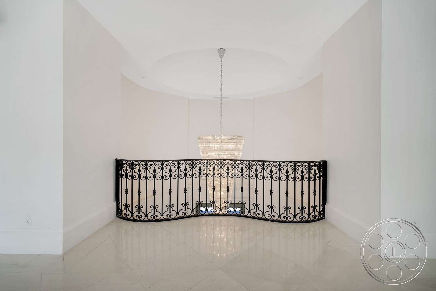 Medit 171 - chandelier lighting, modern architectural style, polished marble flooring, black wrought iron railing, neutral painted walls, curved balcony design, expansive open space, circular ceiling feature