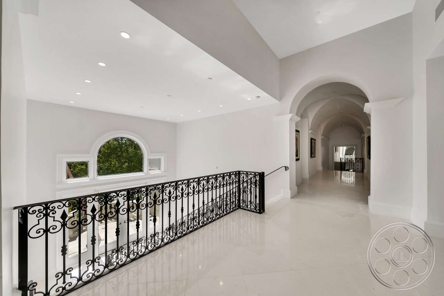 Medit 171 - high ceilings, coffered ceiling, floor-to-ceiling windows, modern architectural style, marble flooring, arched doorways, black wrought iron railing, white painted walls, open hallway design