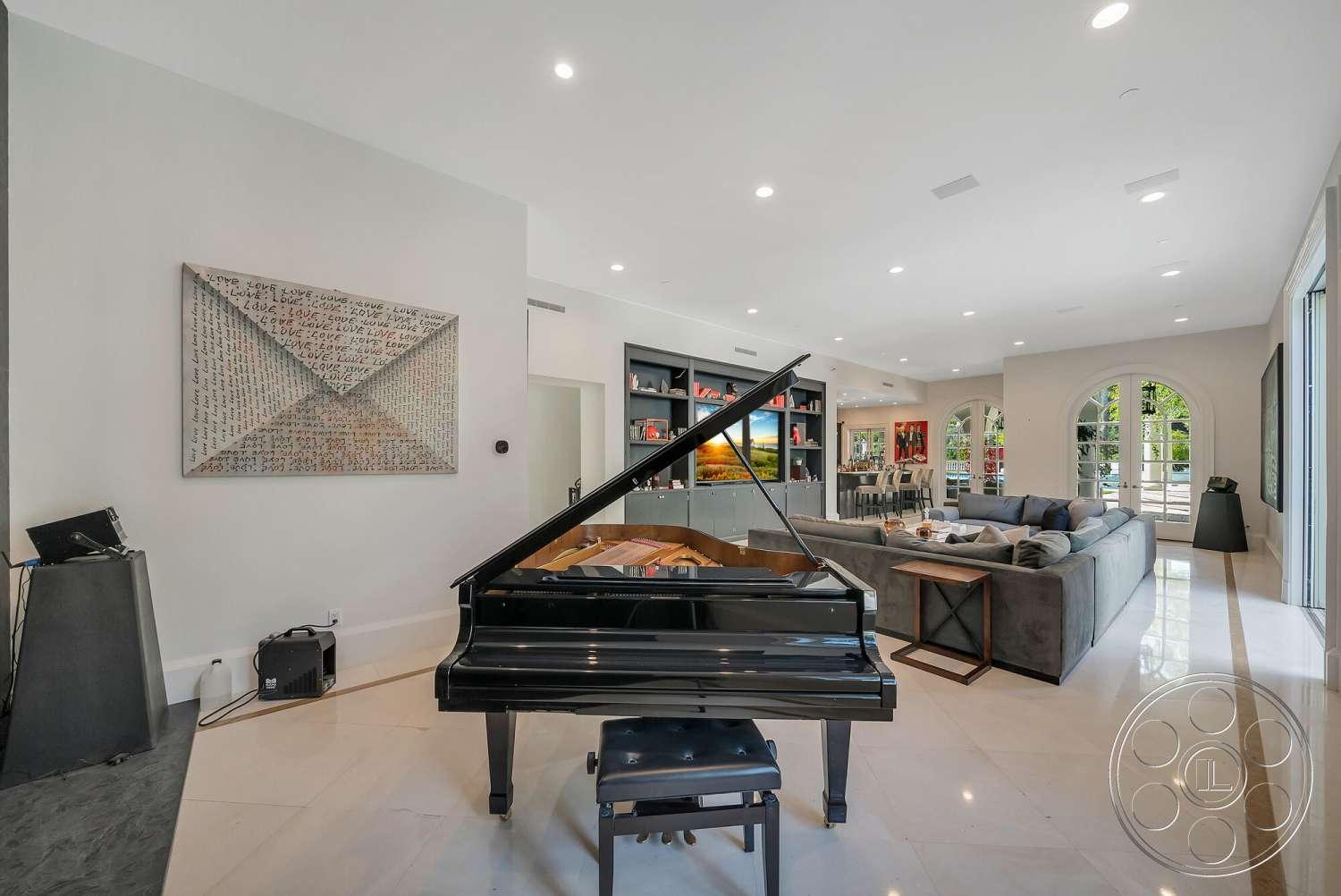 Medit 171 - decorative pillows, framed artwork, modern coffee table, floor-to-ceiling windows, black grand piano, arched doorways, large sectional sofa, light-colored stone flooring, neutral painted walls, built-in shelving units