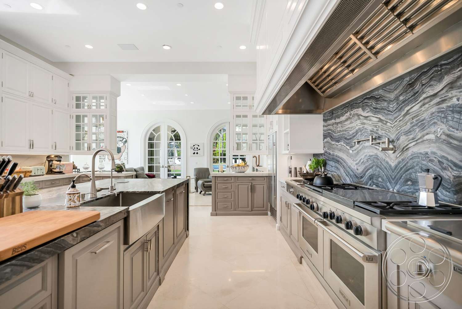 Medit 171 - high ceilings, natural light, recessed lighting, stainless steel appliances, gray cabinetry, open concept layout, floor-to-ceiling windows, marble countertops, double oven, modern kitchen design, interior kitchen, decorative glass cabinet doors, backsplash with stone pattern, island with built-in sink