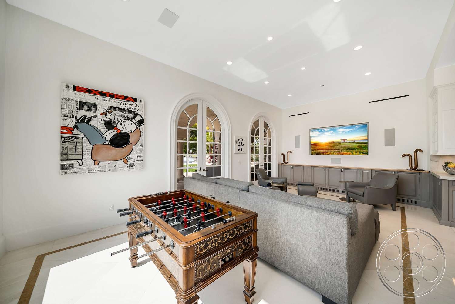 Medit 171 - recessed lighting, glass doors, custom cabinetry, seating area, artwork on wall, vaulted ceiling, marble flooring, luxury living room, arced windows, white painted walls, modern entertainment center, foosball table