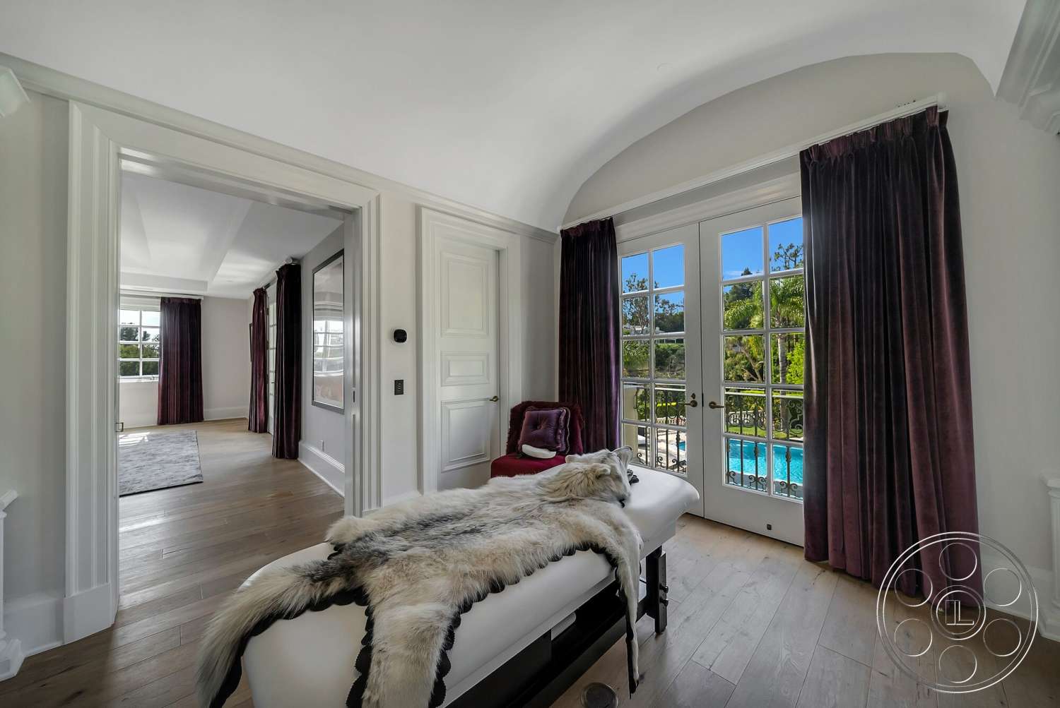Medit 171 - floor-to-ceiling windows, arched doorways, luxury bedroom, hardwood bedroom floors, white painted walls, purple velvet curtains, oval pool view