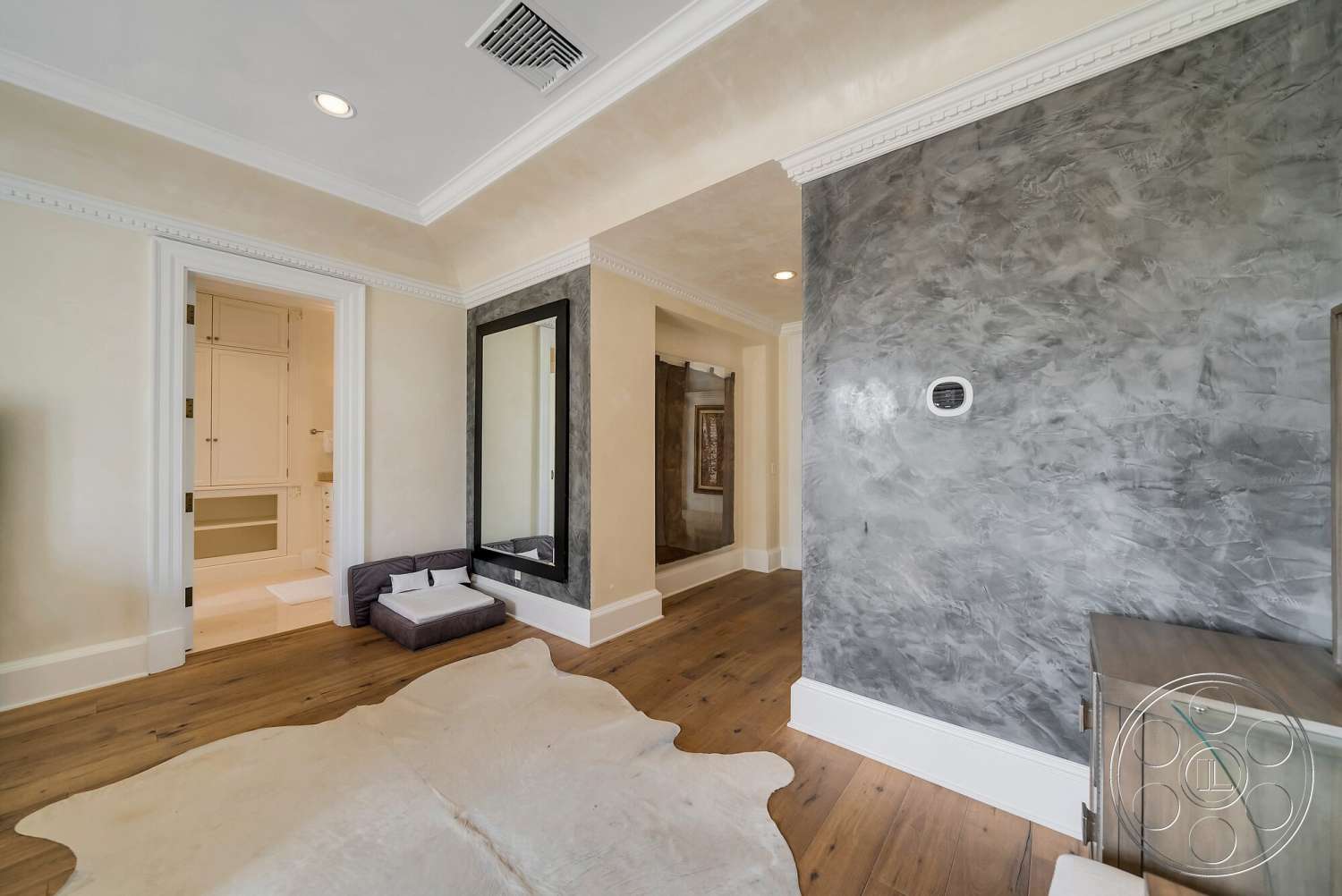 Medit 171 - hardwood flooring, dark accent wall, textured plaster walls, floor-to-ceiling mirror, crown molding details, cohesive neutral color palette, modern wall-mounted thermostat, elegant doorways, stylish furniture arrangement, animal hide area rug