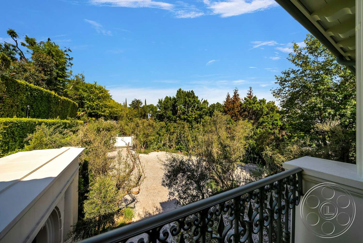 Medit 171 - exterior, lush greenery, stone wall, metal railing, tree canopy, balcony view, cobblestone pathway, sunny environment, mature landscaping