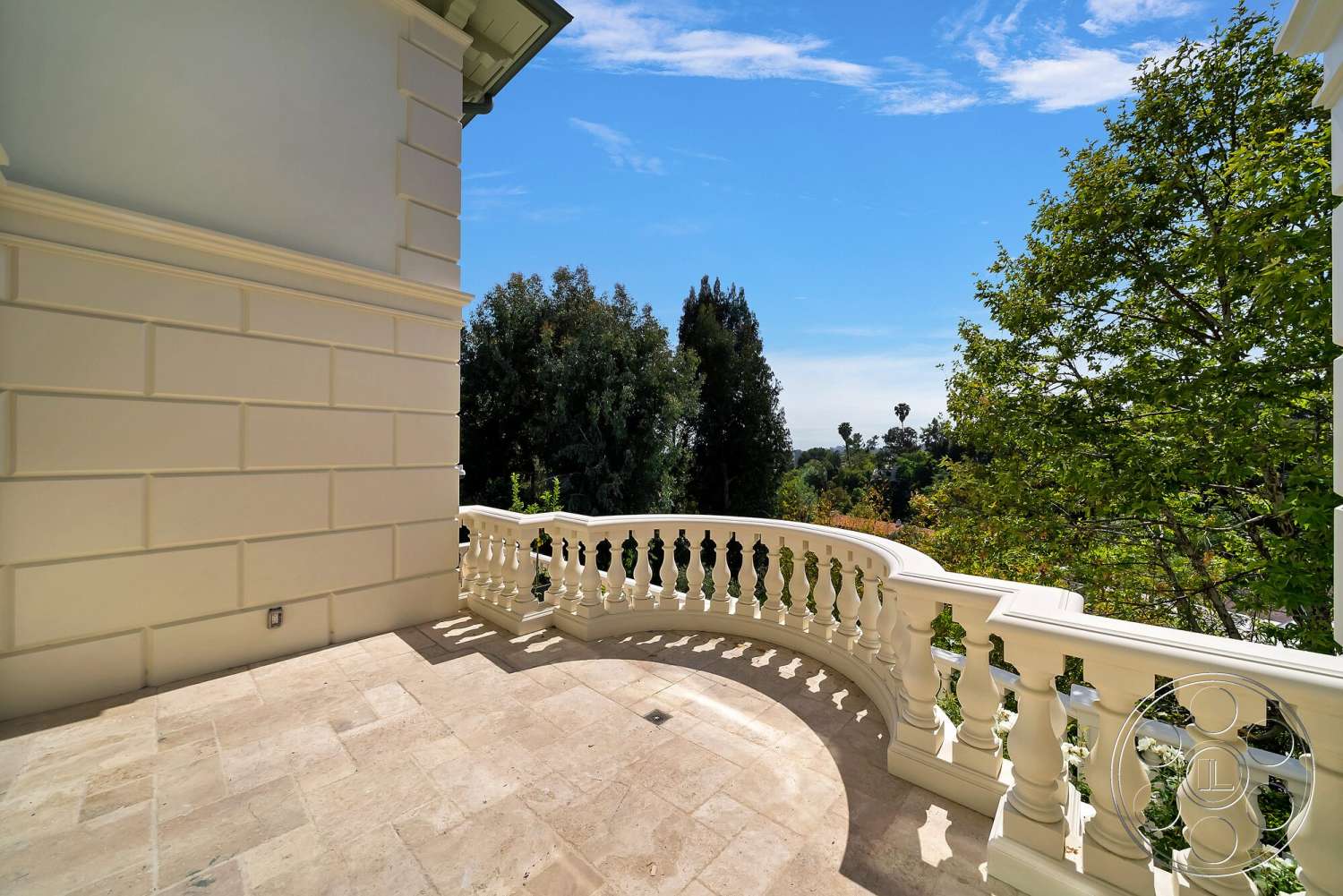Medit 171 - exterior, landscaped garden view, skyline view, white stucco wall, stone patio flooring, curved balcony railing, smooth-textured wall surface, light-colored architectural detailing